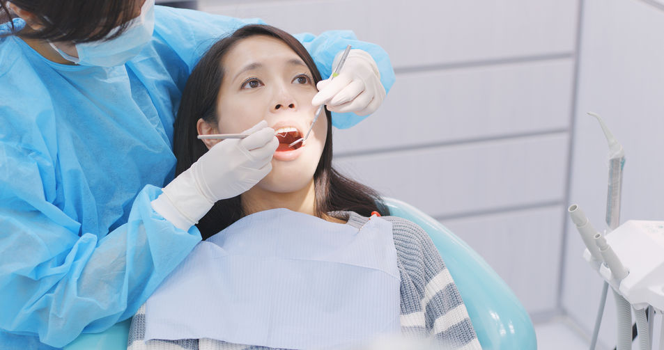 Woman undergo check up of tooth in dental clinic