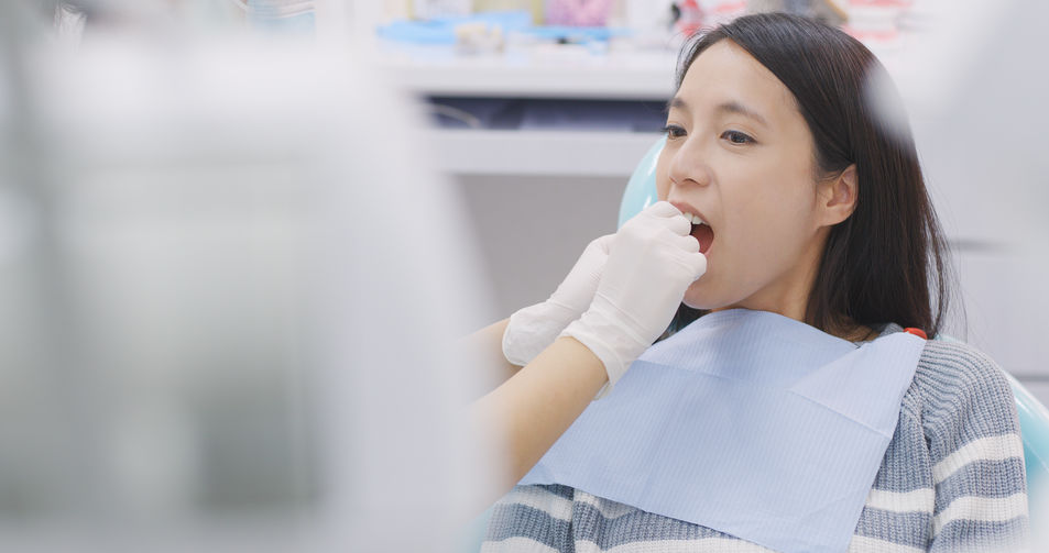 Dentist showing the use of dental floss in clinic Dentist showing the use of dental floss in clinic